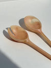 Two wooden spoons on a light surface with a soft shadow. Maegen | Shop Fodder