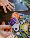 Person holding a colorful card with floral design and text on a wooden surface. Make your own thank you cards | Hadley Paper Goods | Fodder