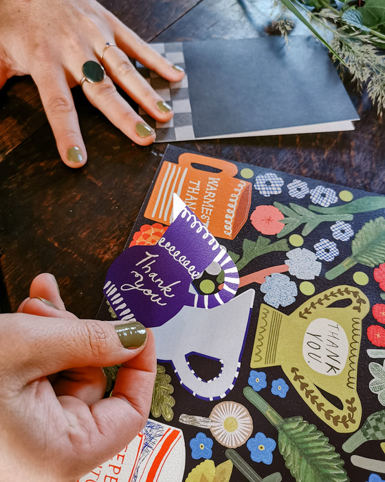 Person holding a colorful card with floral design and text on a wooden surface. Make your own thank you cards | Hadley Paper Goods | Fodder